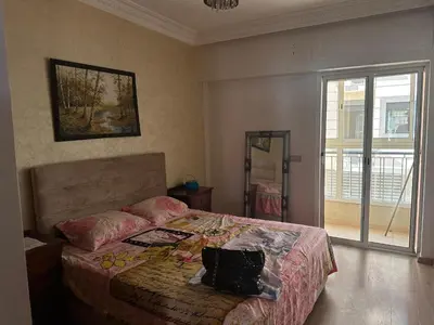 a bedroom with a bed with a pillow on it at Appartement A Darbouazza Tamaris 5min accès a la plage in Tamaris