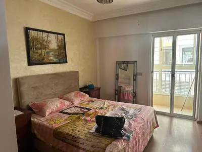 a bedroom with a bed with a pillow on it at Appartement A Darbouazza Tamaris 5min accès a la plage in Tamaris