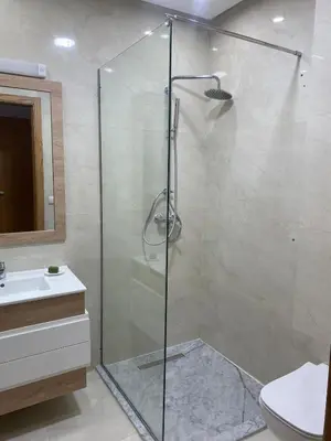 a bathroom with a shower and a toilet and a sink at Appartement neuf avec piscine in Bouznika