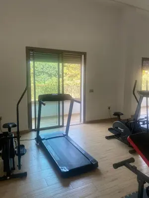 a room with a gym with several exercise bikes at Appartement neuf avec piscine in Bouznika