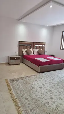 a bedroom with a large bed and a rug at Chambres au sein d'une villa in Rabat