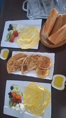 a table topped with plates of breakfast foods with eggs and bread at Chambres au sein d'une villa in Rabat