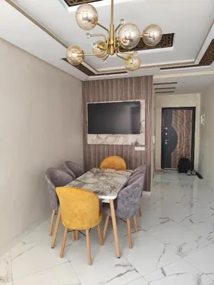 a dining room with a table and chairs and a television at Nid d'anges in Bouznika