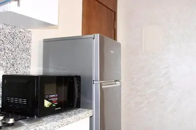 a kitchen with a stainless steel refrigerator and a microwave at Holiday Harmony in Roches Noires