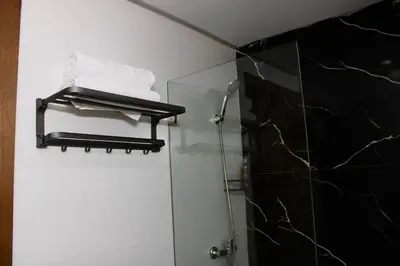 a bathroom with a glass shower stall with towels at Holiday Harmony in Roches Noires