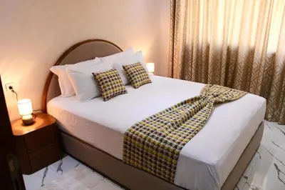 a bedroom with a bed with white sheets and pillows at Holiday Harmony in Roches Noires