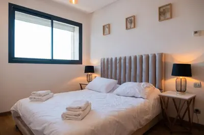 a bedroom with a bed with towels on it at 2BR Prestigia Hay Riad in Rabat