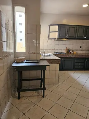 a kitchen with a table in the middle of it at Maarif Central Stay in Maarif