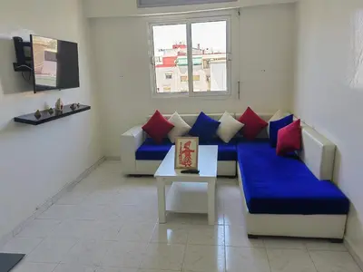 a living room with a blue couch and a table at Mydar ocean in Rabat
