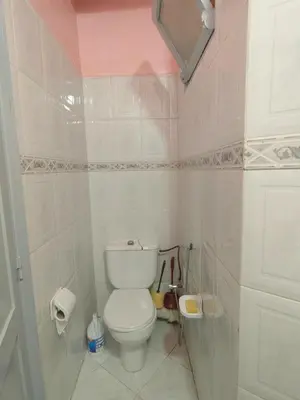 a white bathroom with a toilet and a mirror at Mydar ocean in Rabat