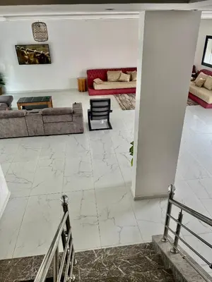 a living room with white marble floors and couches at Spacieuse villa oued cherrat bouznika in Bouznika