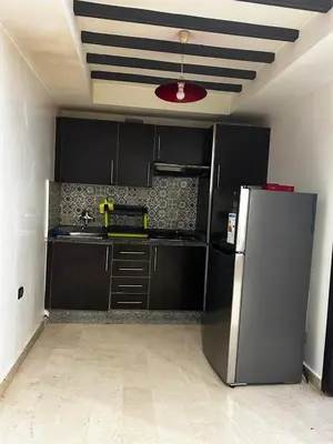 a kitchen with black cabinets and a stainless steel refrigerator at Modern Studio by the Beach of Casablanca Night Stay in Casablanca