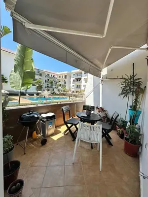 a patio with a table and chairs on a balcony at Les jardins de cherrat in Bouznika