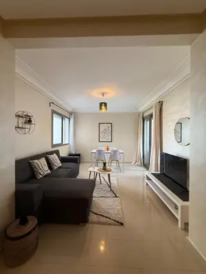 a living room with a couch and a table at Appartement Moderne 2 chambres à Blanca Beach Sidi Rahal in Sidi Rahal