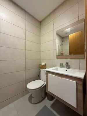 a bathroom with a toilet and a sink and a mirror at Appartement Moderne 2 chambres à Blanca Beach Sidi Rahal in Sidi Rahal