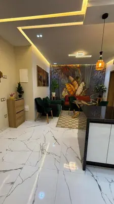 a living room with a marble floor and a painting at Studio lux in Bouznika