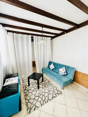 a living room with a blue couch and a table at Loft12 in Rabat