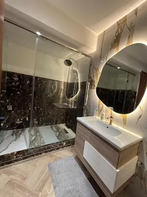 a bathroom with a shower and a sink and a mirror at Escape for the whole family in Casablanca