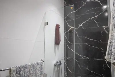 a bathroom with a shower with black marble at Les rochers in Casablanca
