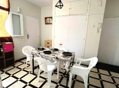 a dining room with a table and white chairs at Appartement Spacieux pour Famille Mâarif Casablanca in Maarif