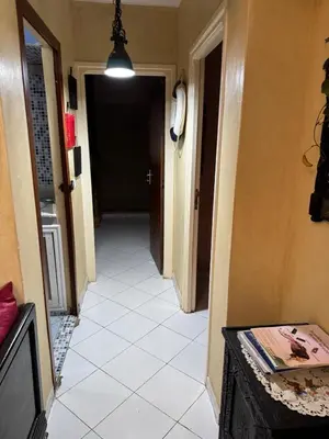 a hallway with a white tiled floor and a black door at Modern appartment in Casablanca
