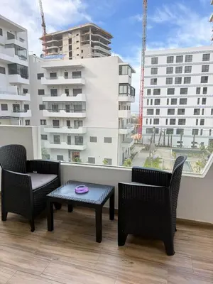 a balcony with chairs and a table and a window at Cozy Studio Vue sur Piscine à Ocean Park Zenata City Eco in Aïn Harrouda