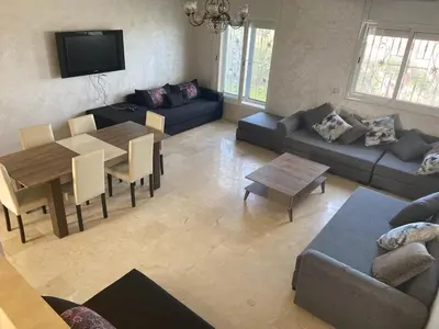 a living room with a couch and a table at Ocean View Villa avec Piscine en Bord de Mer in Sidi Rahal