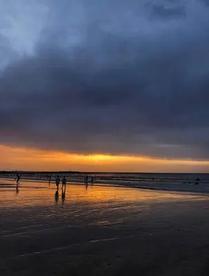 a group of people walking on the beach at sunset at Ocean View Villa avec Piscine en Bord de Mer in Sidi Rahal