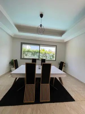 a dining room with a table and chairs and a window at Villa a darbouaza in Dar Bouazza