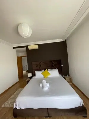 a bedroom with a large white bed with two pillows at Villa a darbouaza in Dar Bouazza