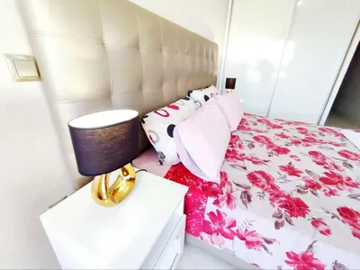 a bedroom with a large bed with pink flowers at Comfortable Apartment Maârif Area in Casablanca