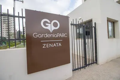 a sign on the side of a building with a gate at Appartement Neuf & Cosy avec vu sur mer -Zenata Eco City- in Aïn Harrouda