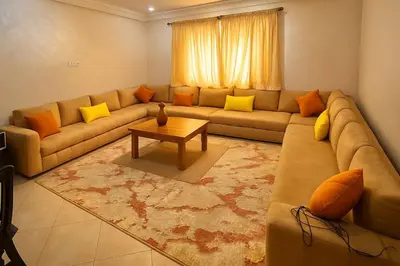 a living room with a couch and a table at Résidence calme 3 chambres pour votre hébergement in Bouznika