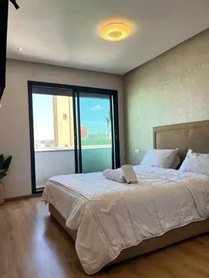 a bedroom with a large bed with a large window at cozy furnished studio fully equipped in Casablanca