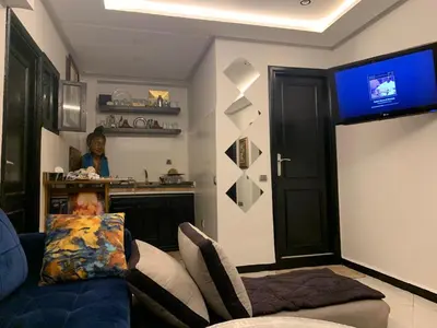 a living room with a blue couch and a tv at Studio Corniche Casablanca in Casablanca