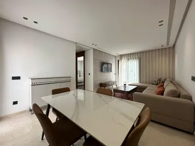a living room with a table and a couch at appartement les princesses 2chmbr salon 2 terasse in Maarif