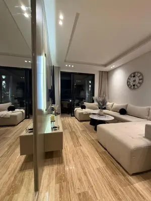 a living room with couches and a clock on the wall at Appartement Haut Standing vue Piscine in Sidi Rahal