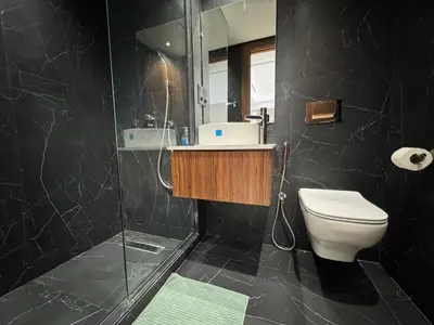 a black bathroom with a toilet and a shower at Modern Studio Princesses District in Maarif