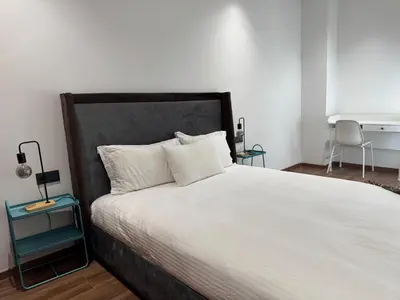 a bedroom with a large bed with white sheets and a desk at Modern Studio Princesses District in Maarif