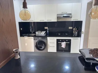 a kitchen with a stove and a washing machine at Les perles de tamaris in Casablanca