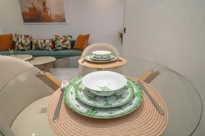 a table with plates and bowls on top of it at Studio Confortable et Cozy 5 min du stade CAN2025- Maarif Casablanca in Casablanca