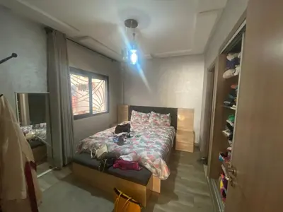 a bedroom with a bed with a cat laying on it at Beach apartment in Bouznika