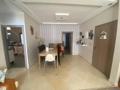 a kitchen and dining room with a table and chairs at Beach apartment in Bouznika