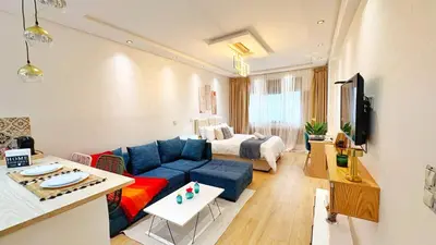 a living room with a blue couch and a bed at Cosy studio Steps to Shore and Tramway in Rabat
