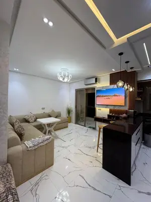 a large living room with a couch and a tv at Cozy studio in Bouznika
