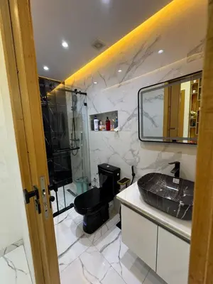 a bathroom with a black toilet and a sink at Cozy studio in Bouznika