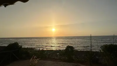 a sunset over the ocean with the sun in the sky at Dar Alyakoute - Harhoura in Temara