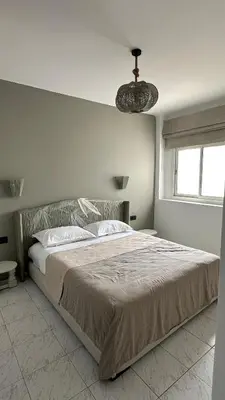 a bedroom with a large bed and a chandelier at Dar Alyakoute - Harhoura in Temara