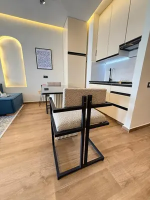 a living room with a table and chairs and a kitchen at New apartment in the heart of Rabat in Rabat