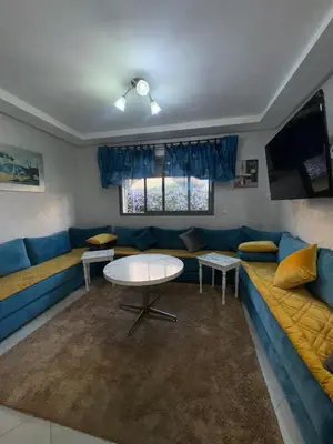 a living room with a blue couch and a table at Residence sables dor Mohammedia in Mohammedia